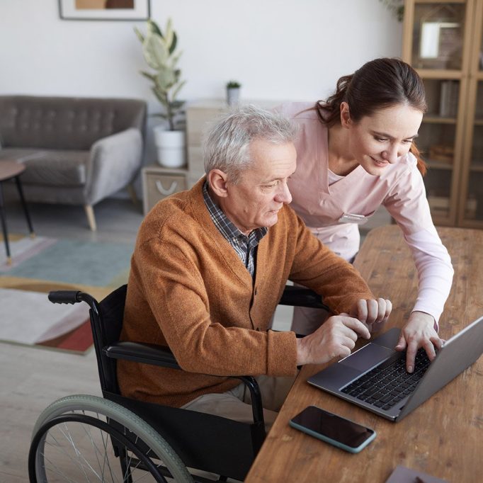 Therapist for Seniors in San Antonio Medicare Texas senior-aged man in a wheelchair gets help from care worker logging on to online therapy session