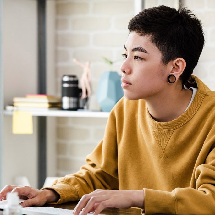 Therapist for LGBTQ Gen Z Young Adult in Texas a non-binary LGBTQ+ person logs into online therapy session in Texas
