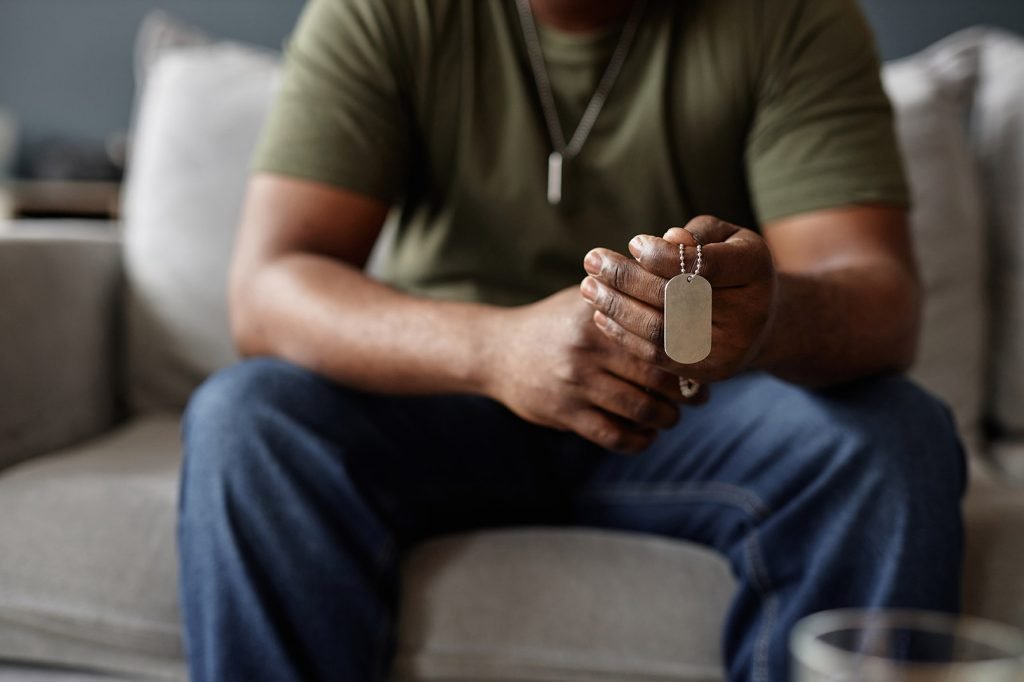 A military veteran holds his friends' dog tag during therapy session in Military City San Antonio using TriWest