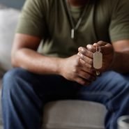 A military veteran holds his friends' dog tag during therapy session in Military City San Antonio using TriWest