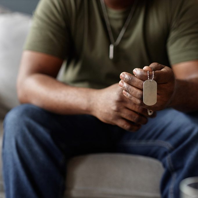 A military veteran holds his friends' dog tag during therapy session in Military City San Antonio using TriWest