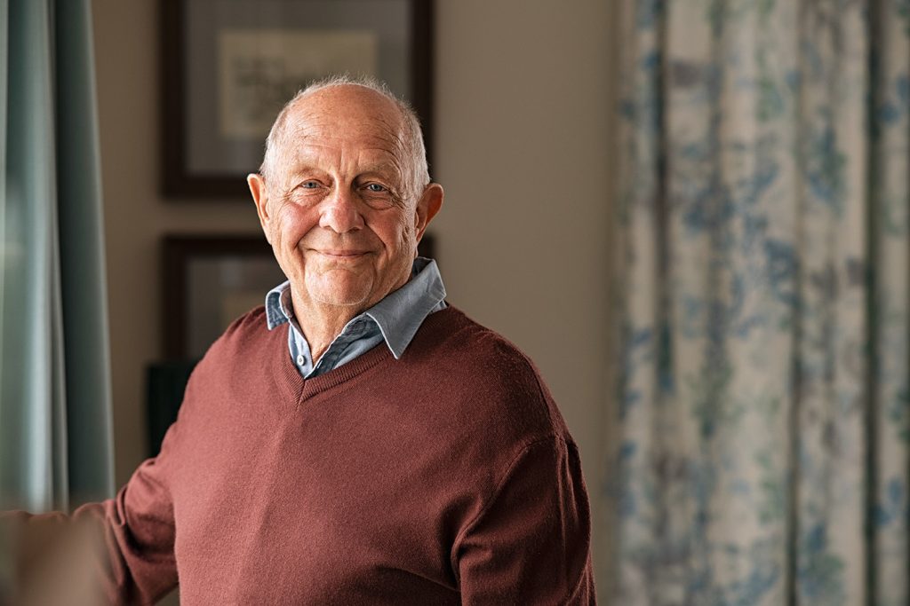 Online Therapist for Geriatric Adults in Texas an elderly man reservedly smiles at the camera